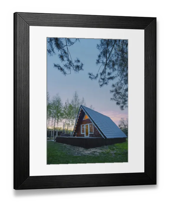 Framed Print : A-frame wooden cabin with light inside in early evening