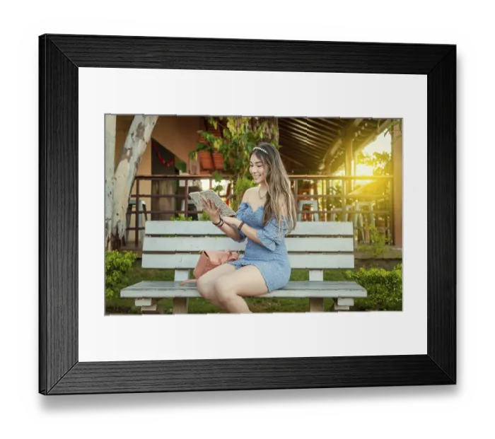 Framed Print : A cute girl sitting on a bench reading a book