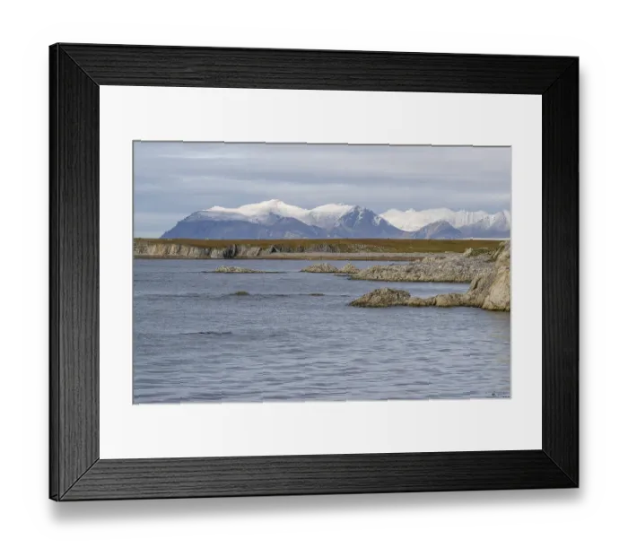 Framed Print : Rocks, coastal landscape, snowy mountains