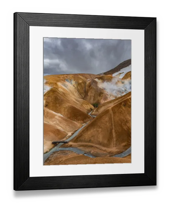 Framed Print : Bridge over steaming stream between colourful rhyolite mountains with snowfields