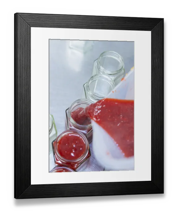 Framed Print : Red jam is filled into jars, fruity and fresh Framed Print : Red jam is filled into jars, fruity and fresh