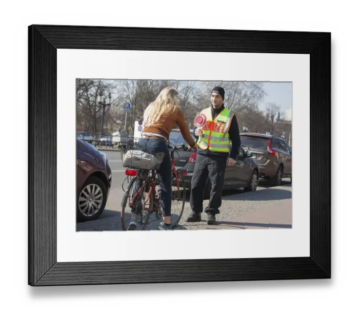 Framed Print : A Berlin police officer stops a cyclist during a traffic stop