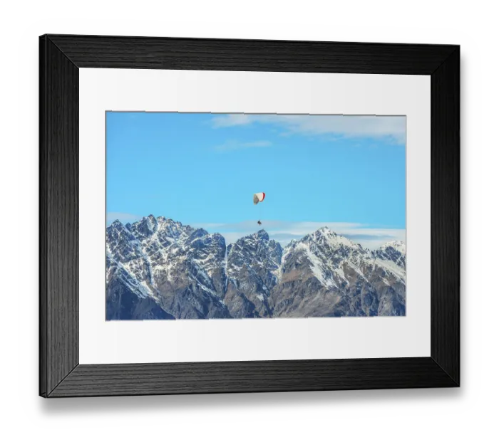 Framed Print : Paragliding over the snowcapped Remarkables mountain range
