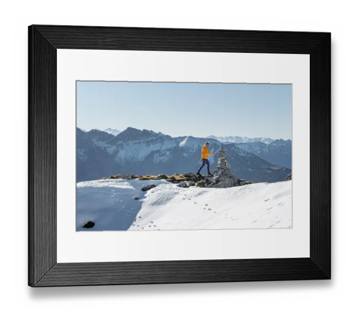 Framed Print : Mountaineer looks over snow-covered mountains