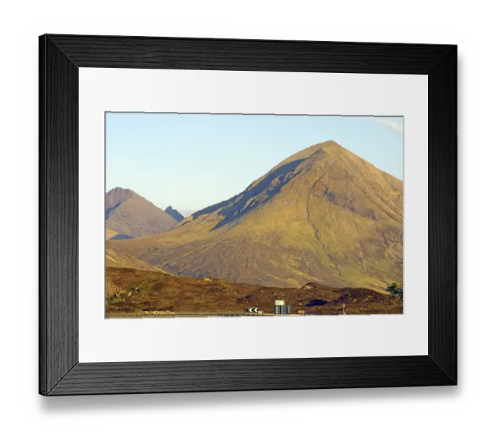 Framed Print : Large single mountain with rocky surface illuminated by yellow sunlight under a clear blue sky Framed Print : Large single mountain with rocky surface illuminated by yellow sunlight under a clear blue sky