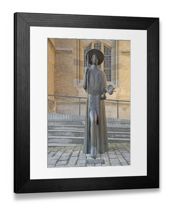 Framed Print : Sculpture Pilgrim with staff and scallop shell and monument to the Way of St James in front of St James Church