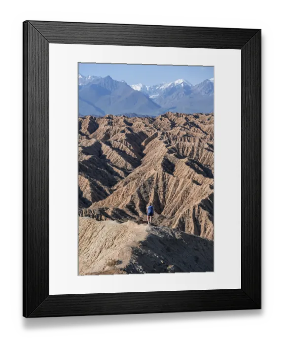 Framed Print : Hiker walking along a canyon, Tian Shan mountains in the background