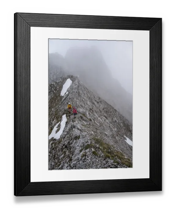 Framed Print : Two mountaineers with helmets in the mountains in fog