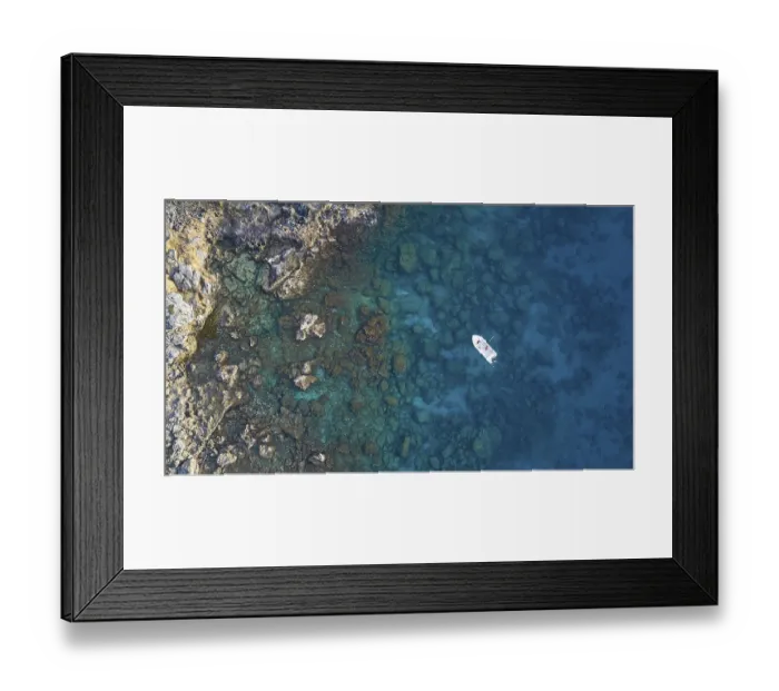 Framed Print : Drone shot, boat in clear blue water next to rocks and corals