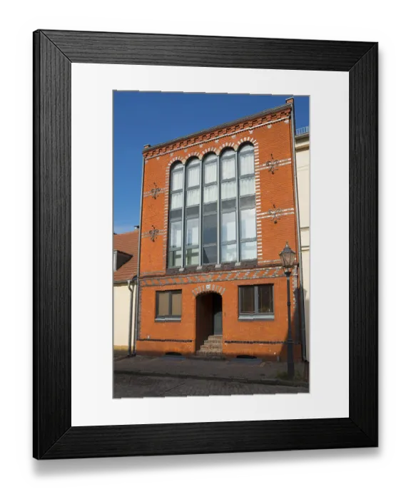 Framed Print : Historic building with brick facade and large windows under a clear sky