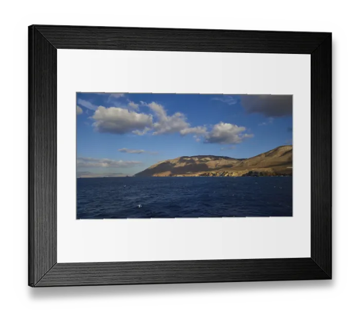 Framed Print : View of a wide seascape with mountains on the horizon under a blue sky