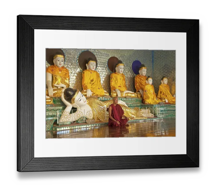 Framed Print : Buddhist monk praying in front of Buddha statues at the Shwedagon Zedi Daw Pagoda in Yangon