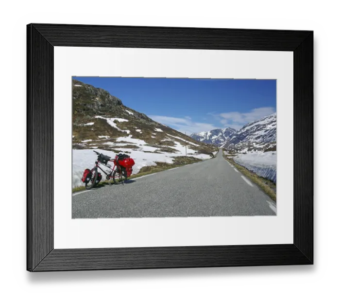 Framed Print : Snow walls and touring bike along a road
