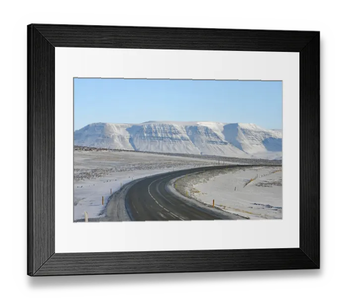 Framed Print : Snowy road leads to a snow-covered mountain range under a clear blue sky