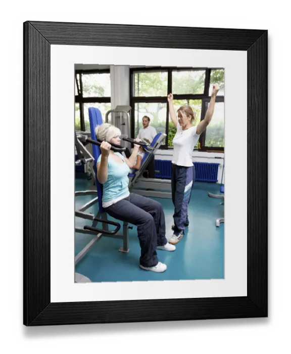 Framed Print : Patients during muscle strength training on various machines in the training room
