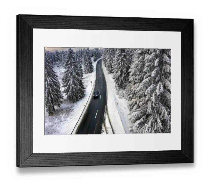 Framed Print : Aerial view, road leads through a snow-covered forest area near Sankt Andreasberg