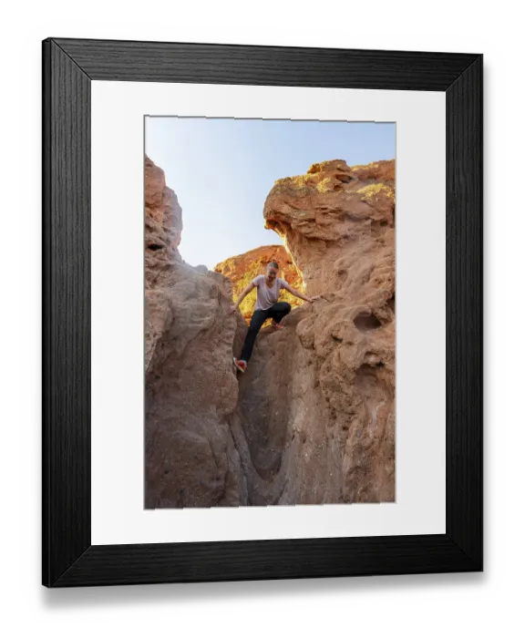Framed Print : Young woman climbing between red sandstone rocks