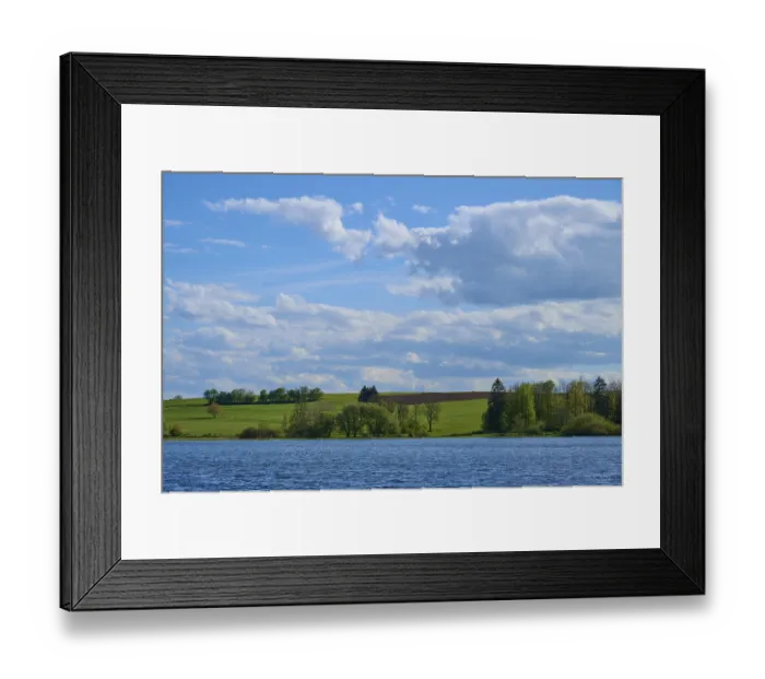 Framed Print : Ober- Moosersee surrounded by green fields and trees under a partly cloudy blue sky Framed Print : Ober- Moosersee surrounded by green fields and trees under a partly cloudy blue sky