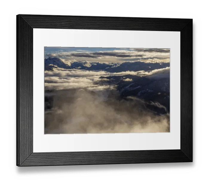 Framed Print : Mountain peaks rise above high fog in the evening light
