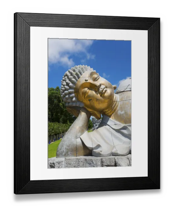Framed Print : Close-up of a reclining Buddha statue radiating meditative calm against a clear blue sky