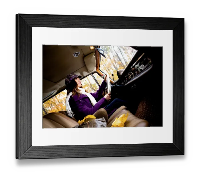 Framed Print : Young woman driving a vintage car