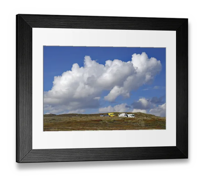 Framed Print : Motorhomes on a hilly landscape under large