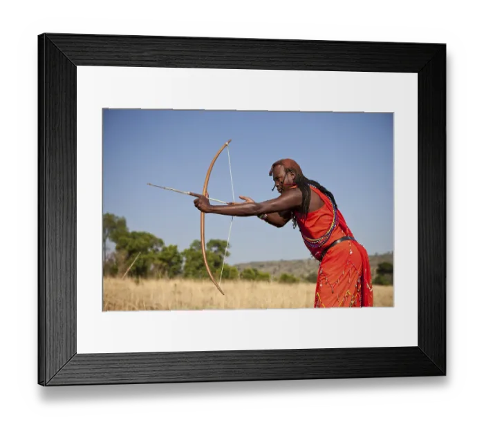 Framed Print : Maasai warrior wearing traditional dress while doing archery with a bow and arrow Framed Print : Maasai warrior wearing traditional dress while doing archery with a bow and arrow
