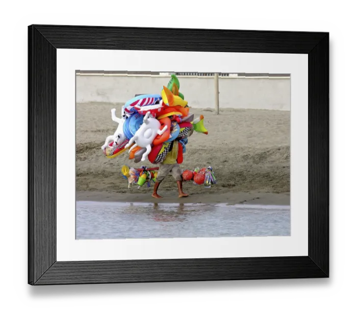 Framed Print : Flying merchant, seller overloaded with large quantities of beach toys