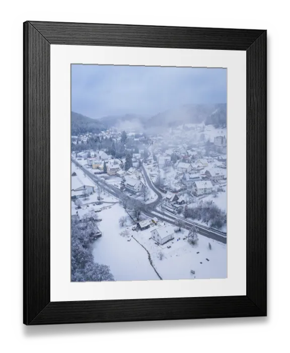 Framed Print : Small snow-covered village in a wooded mountain landscape