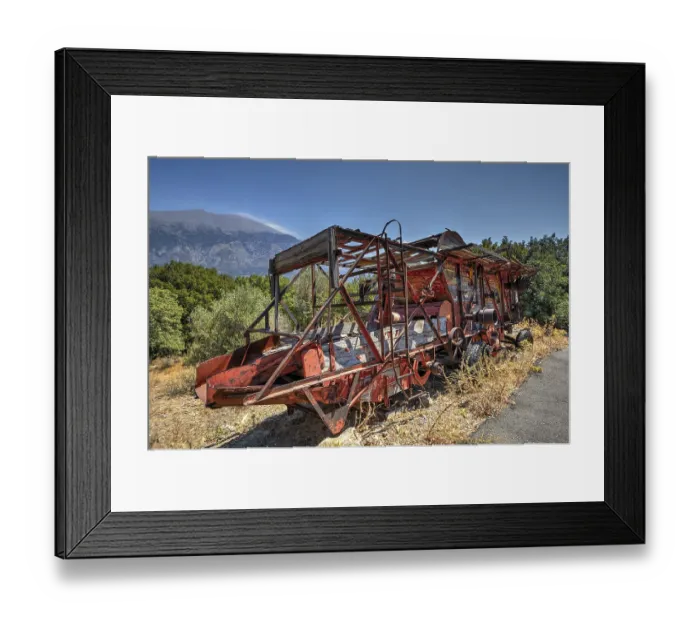 Framed Print : Old, rusty combine harvester in mountainous landscape with clear sky