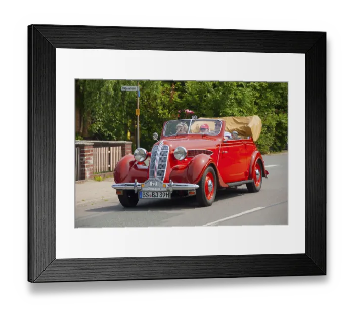 Framed Print : Lively red vintage convertible with top down and passengers on board