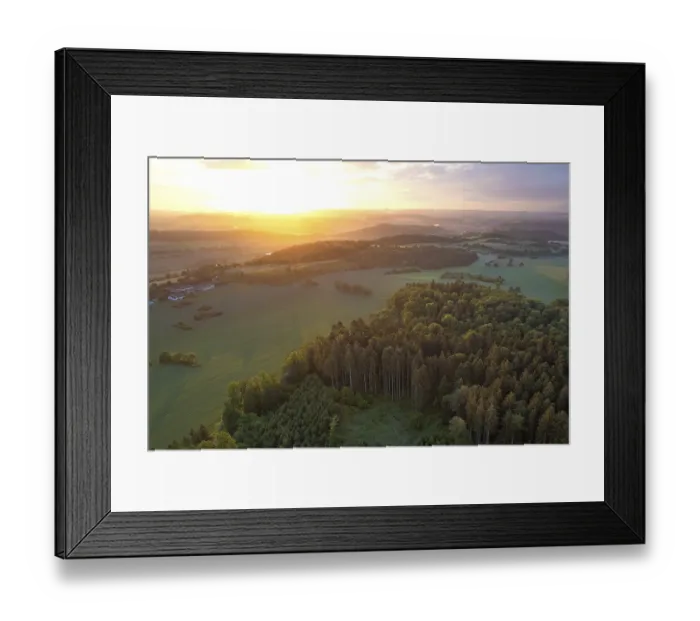 Framed Print : Aerial view of a landscape with forest in the foreground at sunset