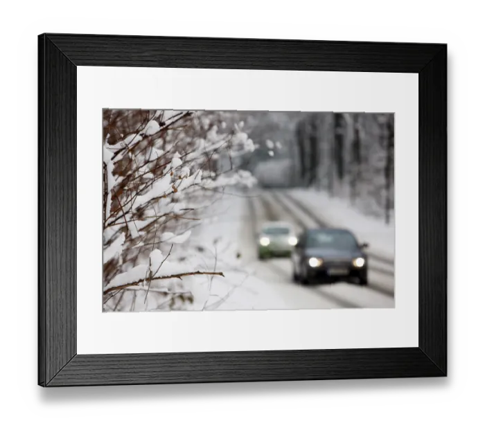 Framed Print : Snow-covered country road in a forest