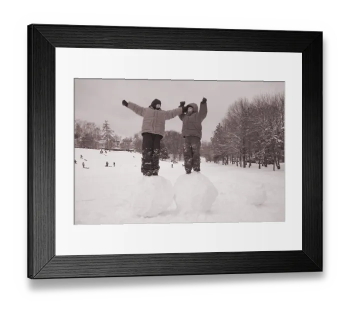 Framed Print : Two boys standing on big snoww balls