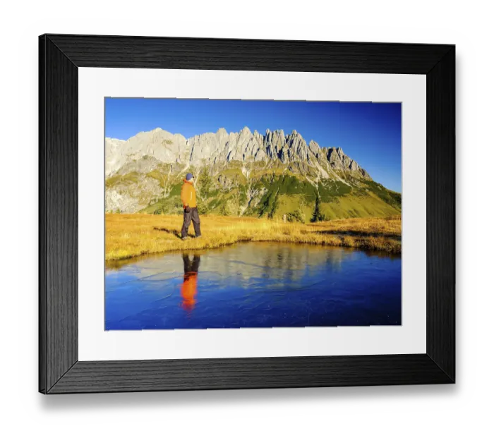 Framed Print : Mountaineer in front of mountain scenery reflected in a frozen mountain lake Framed Print : Mountaineer in front of mountain scenery reflected in a frozen mountain lake