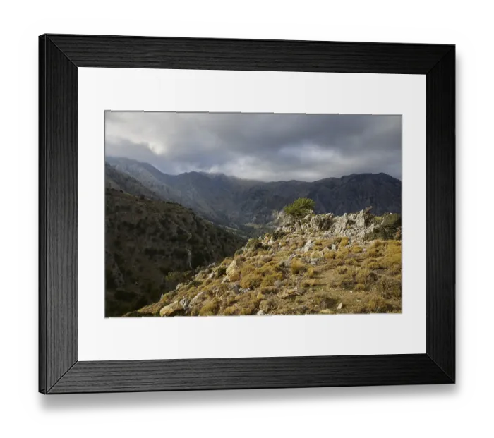 Framed Print : Dark cloud cover hangs over a wild mountain landscape