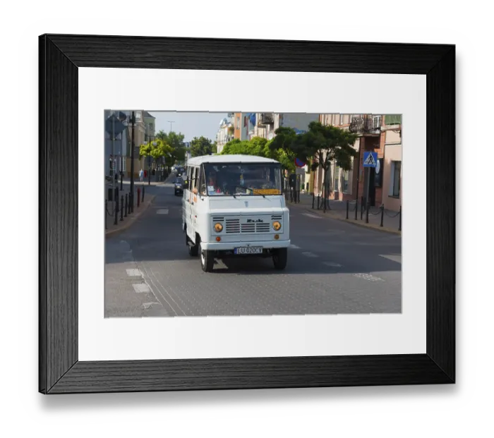Framed Print : White minibus in an urban environment on a busy street