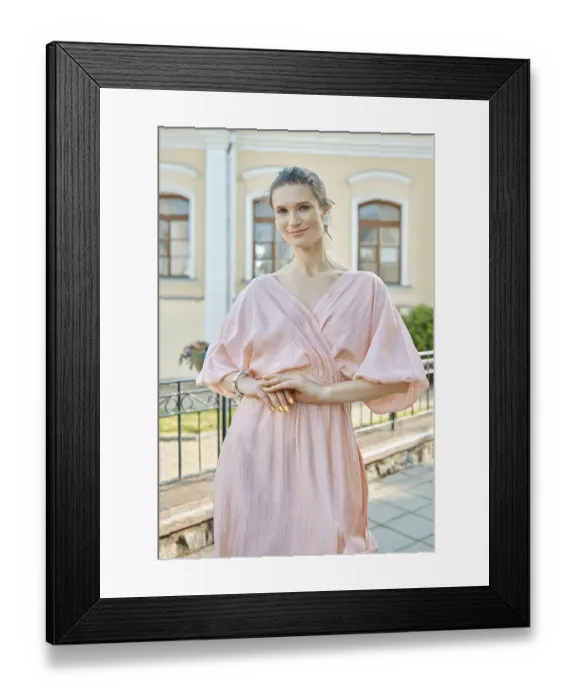 Framed Print : Woman in pink dress poses gracefully outdoors near a charming building on a sunny day