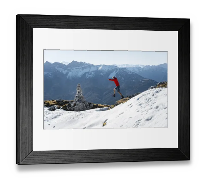 Framed Print : Mountaineer jumping, next to a cairn Framed Print : Mountaineer jumping, next to a cairn