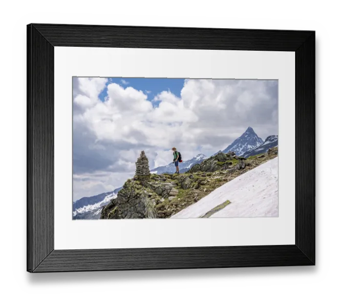 Framed Print : Mountaineer on a rocky hiking trail with cairns