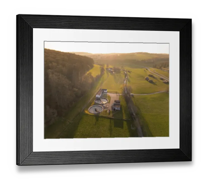 Framed Print : Sewage treatment plant between green fields and a forest
