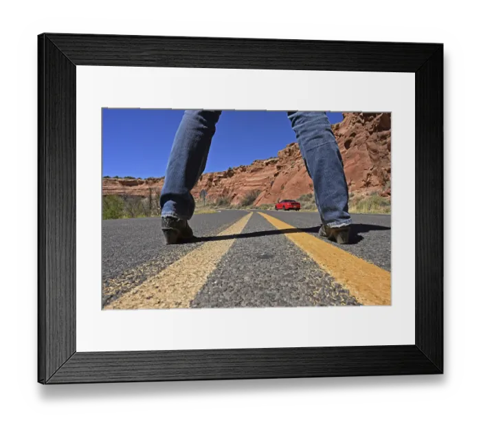 Framed Print : Woman standing in the middle of Route 66 looking at red Ford Mustang convertible