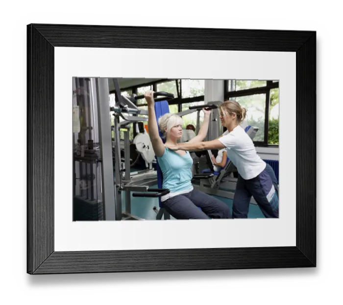 Framed Print : Patients during muscle strength training on various machines in the training room