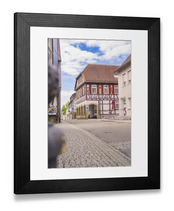 Framed Print : Half-timbered building on a cobbled street under a blue sky Framed Print : Half-timbered building on a cobbled street under a blue sky