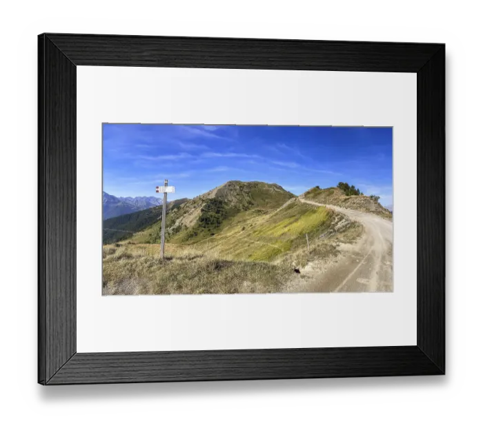 Framed Print : View to Monte Gevris, hiking signpost to Colle Costapiana and gravel road Assietta ridge road