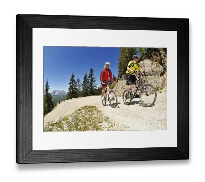 Framed Print : Mountain bikers riding downhill to Kreuzangeralm