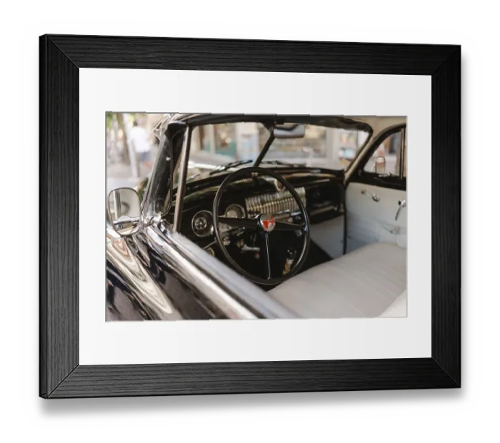 Framed Print : A vintage car with a black steering wheel and a white dashboard