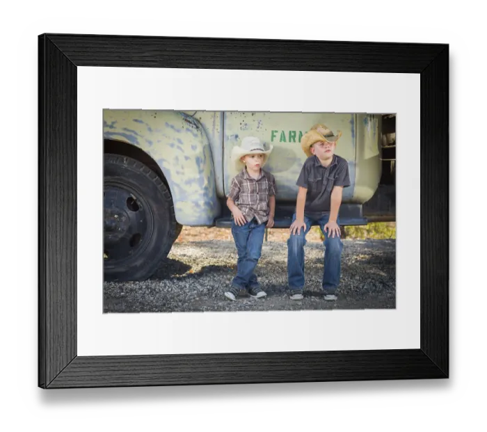 Framed Print : Two young boys wearing cowboy hats leaning against an antique truck in a rustic country setting
