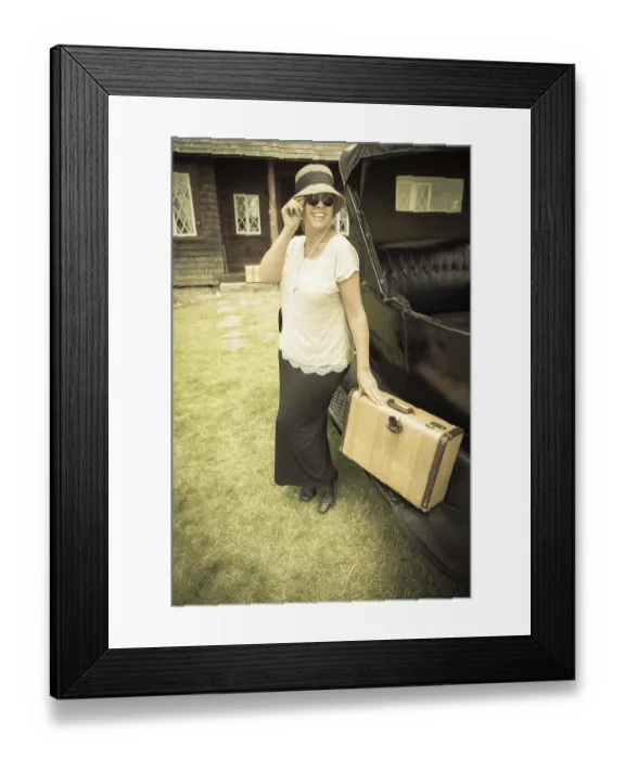 Framed Print : Happy 1920s dressed girl holding suitcase next to vintage car and cabin