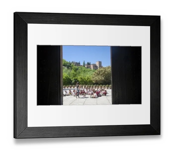 Framed Print : School children listen to their teacher on an educational visit to the historic sites of Granada
